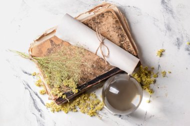 Kristal falcı küresi, büyü kitabı ve parşömen masanın üstünde.