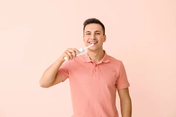 Joven Con Cepillo Dientes Eléctrico Sobre Fondo Color — Foto de Stock