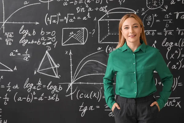 Sınıfta tahtanın yanında olgun matematik öğretmeni.