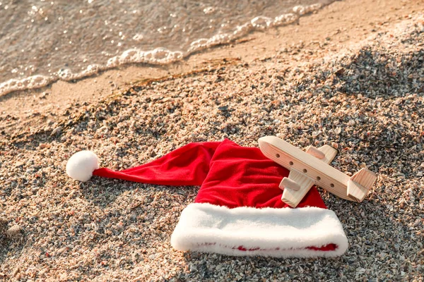 Kerstman Hoed Speelgoed Vliegtuig Zee Strand Kerstvakantie Concept — Stockfoto