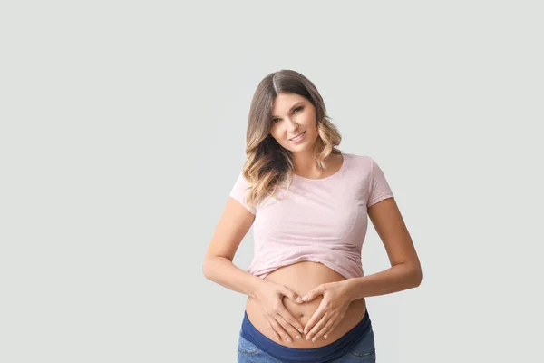 Hermosa Mujer Embarazada Haciendo Corazón Con Sus Manos Sobre Fondo —  Fotos de Stock