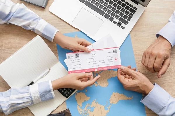 Travel agent giving client  tickets for future trip in office