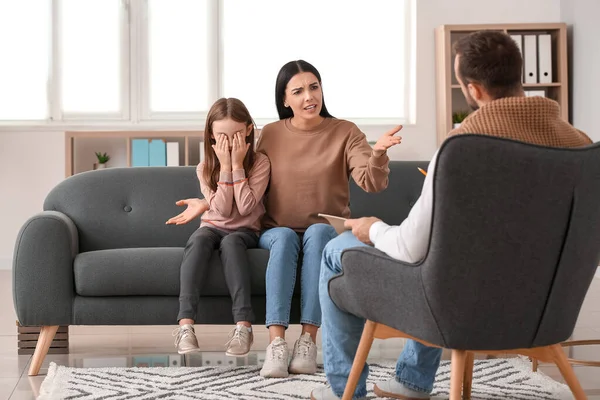 Unhappy family visiting psychologist in office