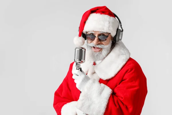凉爽的圣诞老人 带着话筒在灰色背景下唱圣诞歌曲 — 图库照片