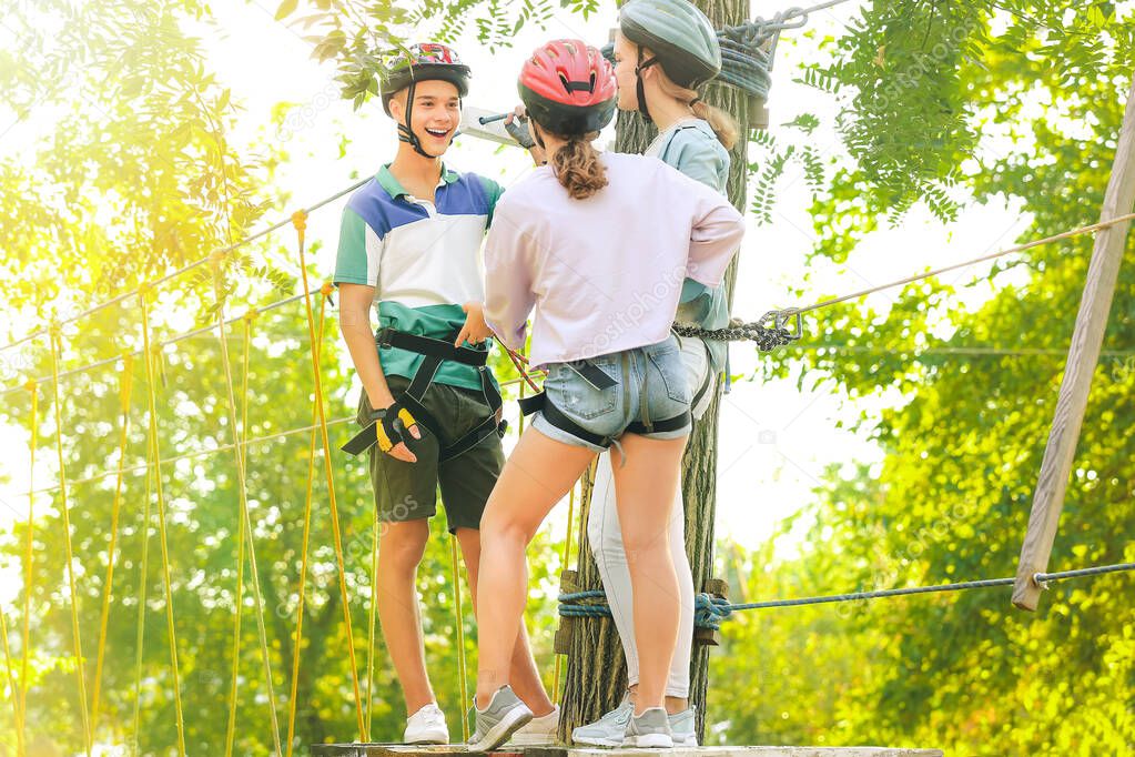 Teenagers climbing in adventure park