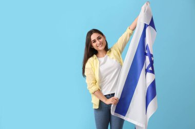 Young woman with the flag of Israel on color background clipart