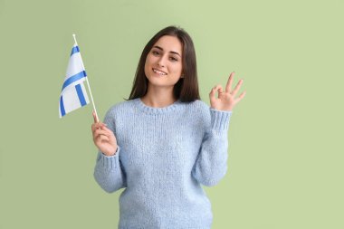 İsrail bayrağı taşıyan genç bir kadın arka planda iyi görünüyor.