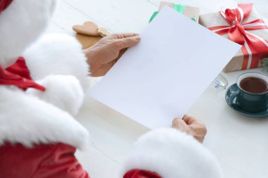 Masasında boş bir mektup olan Noel Baba.