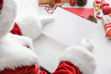 Masasında boş bir mektup olan Noel Baba.