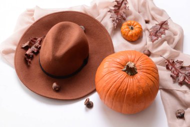 Beyaz arka planda şık giysiler ve balkabaklarıyla sonbahar kompozisyonu