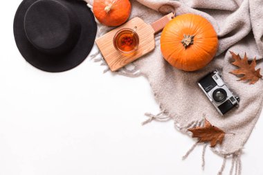 Beyaz arka planda şık giysiler ve balkabaklarıyla sonbahar kompozisyonu