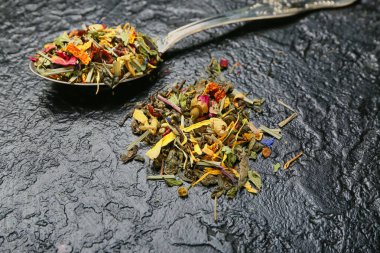 Koyu arkaplanda kuru meyve çayı ile kaşık