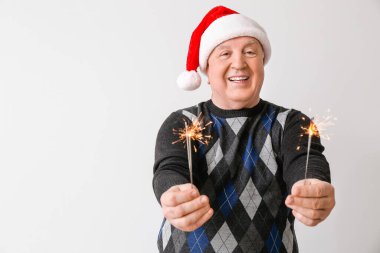 Işık arka planında Noel havai fişekleri olan son sınıf öğrencisi.