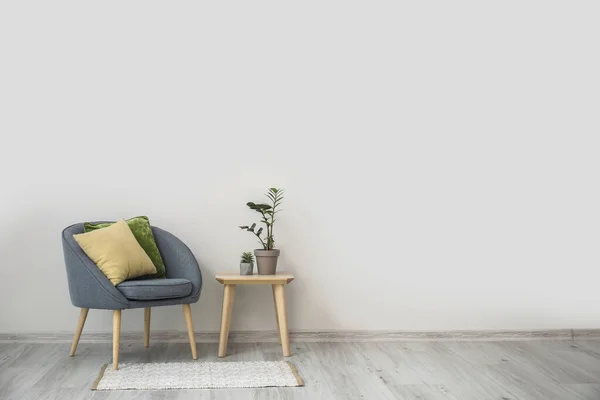 Stylish Armchair Pillows Table Houseplants Light Wall Room —  Fotos de Stock