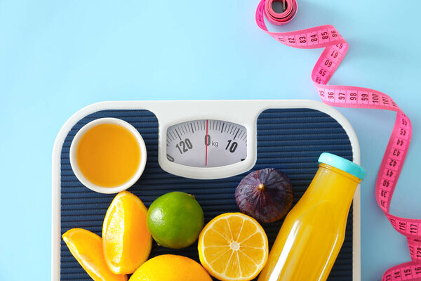 Fresh products, scales and measuring tape on color background. Diet concept