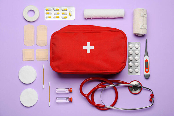 Комплект первой помощи на цветном фоне