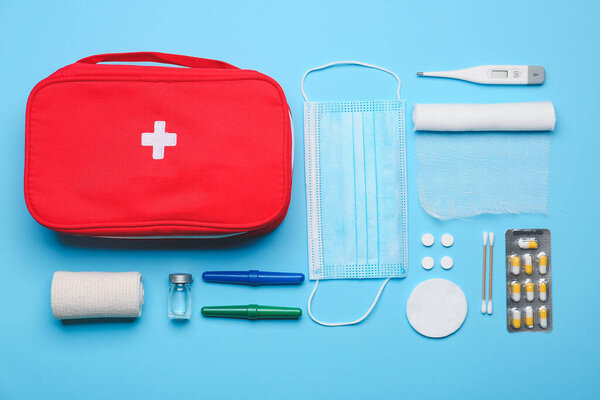 Комплект первой помощи на цветном фоне