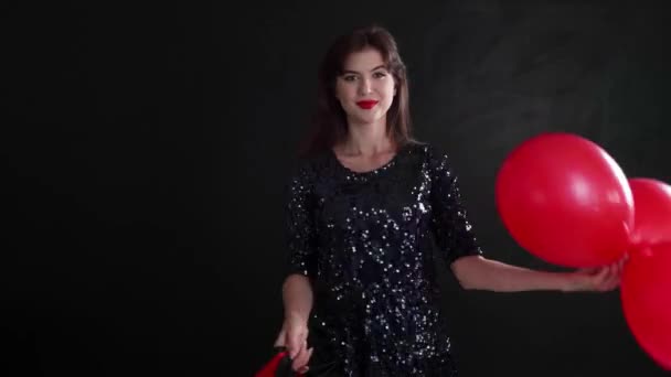 Schöne Junge Frau Mit Einkaufstaschen Und Luftballons Auf Dunklem Hintergrund — Stockvideo