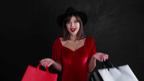 暗い背景にショッピングバッグと幸せな若い女性 ブラック フライデーセール — ストック動画