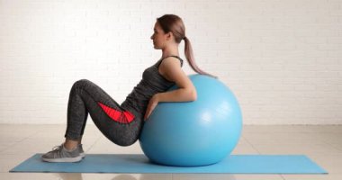 Sportif genç bir kadın spor salonunda spor yapıyor.