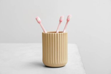 Beyaz masanın üzerinde diş fırçası olan tutucu