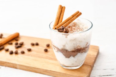 Tahtada tarçınlı bir bardak lezzetli sütlaç.