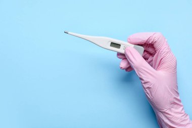 Renk arkaplanı termometresi olan doktorun eli