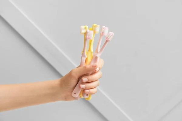Mão Feminina Com Diferentes Escovas Dentes Fundo Claro — Fotografia de Stock