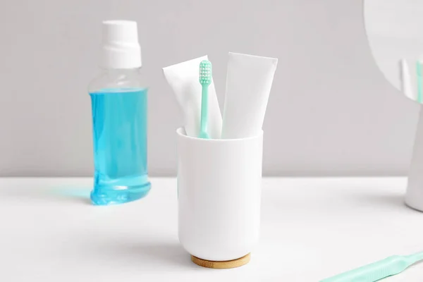 Toothbrush with mouth rinse and paste on table in bathroom