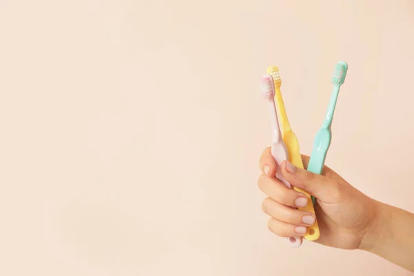 Mano Femenina Con Diferentes Cepillos Dientes Sobre Fondo Color — Foto de Stock