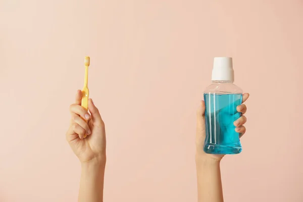 Weibliche Hände Mit Zahnbürsten Und Mundspülung Auf Farbigem Hintergrund — Stockfoto
