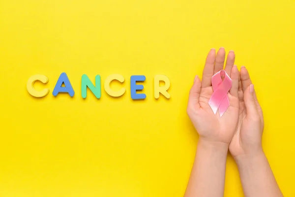 Word Cancer Och Kvinnliga Händer Med Rosa Band Färg Bakgrund — Stockfoto