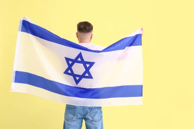 Arka planda İsrail bayrağı olan bir adam.