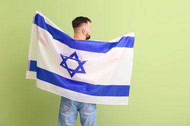 Arka planda İsrail bayrağı olan bir adam.