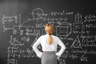 Sınıfta tahtanın yanında olgun matematik öğretmeni.
