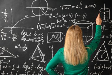 Sınıfta tahtanın yanında olgun matematik öğretmeni.