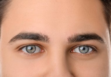 Handsome young man with corrected shape of eyebrows, closeup clipart
