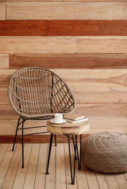 Sandalye, puf ve masa odasındaki tahta duvarın yanında.