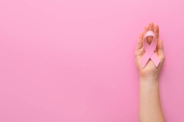 Renkli pembe kurdeleli bir el. Göğüs kanseri farkındalığı konsepti