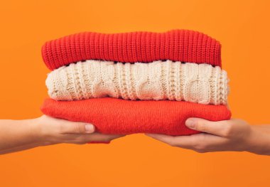 Renkli arka planda kalın giysili kadın elleri