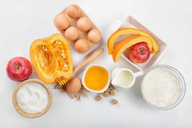 Beyaz arkaplanda balkabağı turtası hazırlamak için gerekli malzemeler