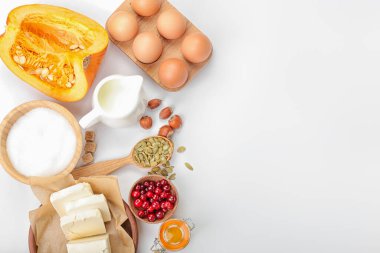 Beyaz arkaplanda balkabağı turtası hazırlamak için gerekli malzemeler