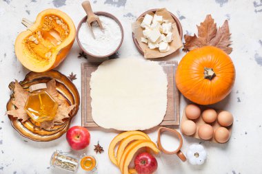 Hafif arkaplanda balkabağı turtası hazırlamak için gerekli malzemeler