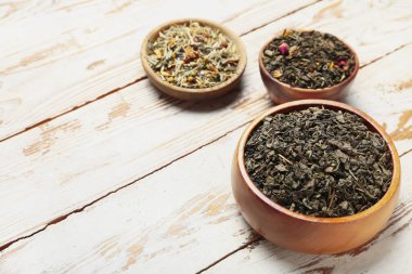 Masanın üzerinde farklı meyve çayları olan kaseler.