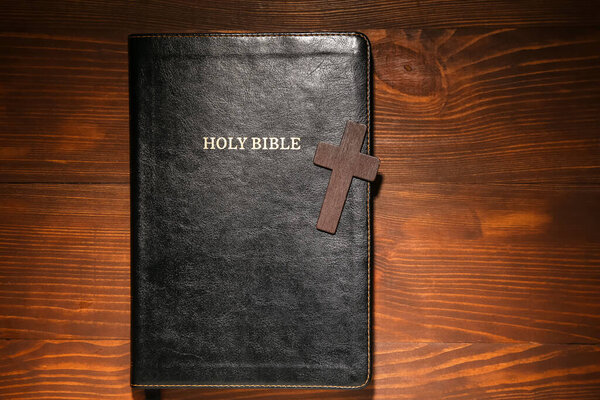 Библия и крест на деревянном фоне