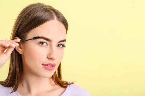 Junge Frau Unterzieht Sich Augenbrauenkorrektur Vor Farbigem Hintergrund — Stockfoto