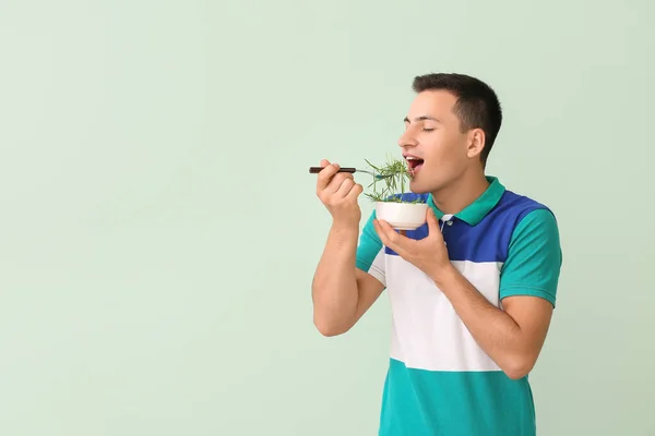 Joven Comiendo Hierba Trigo Sobre Fondo Color — Foto de Stock