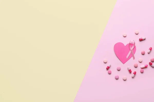 Pink ribbon, heart and pills on color background. Breast cancer awareness concept