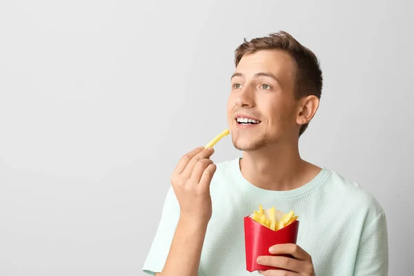 Joven Con Papas Fritas Sobre Fondo Claro —  Fotos de Stock