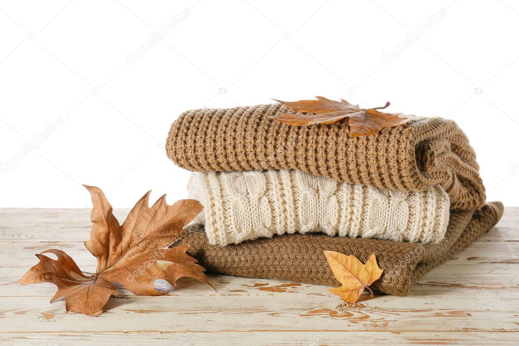 Stylish autumn clothes on table against white background